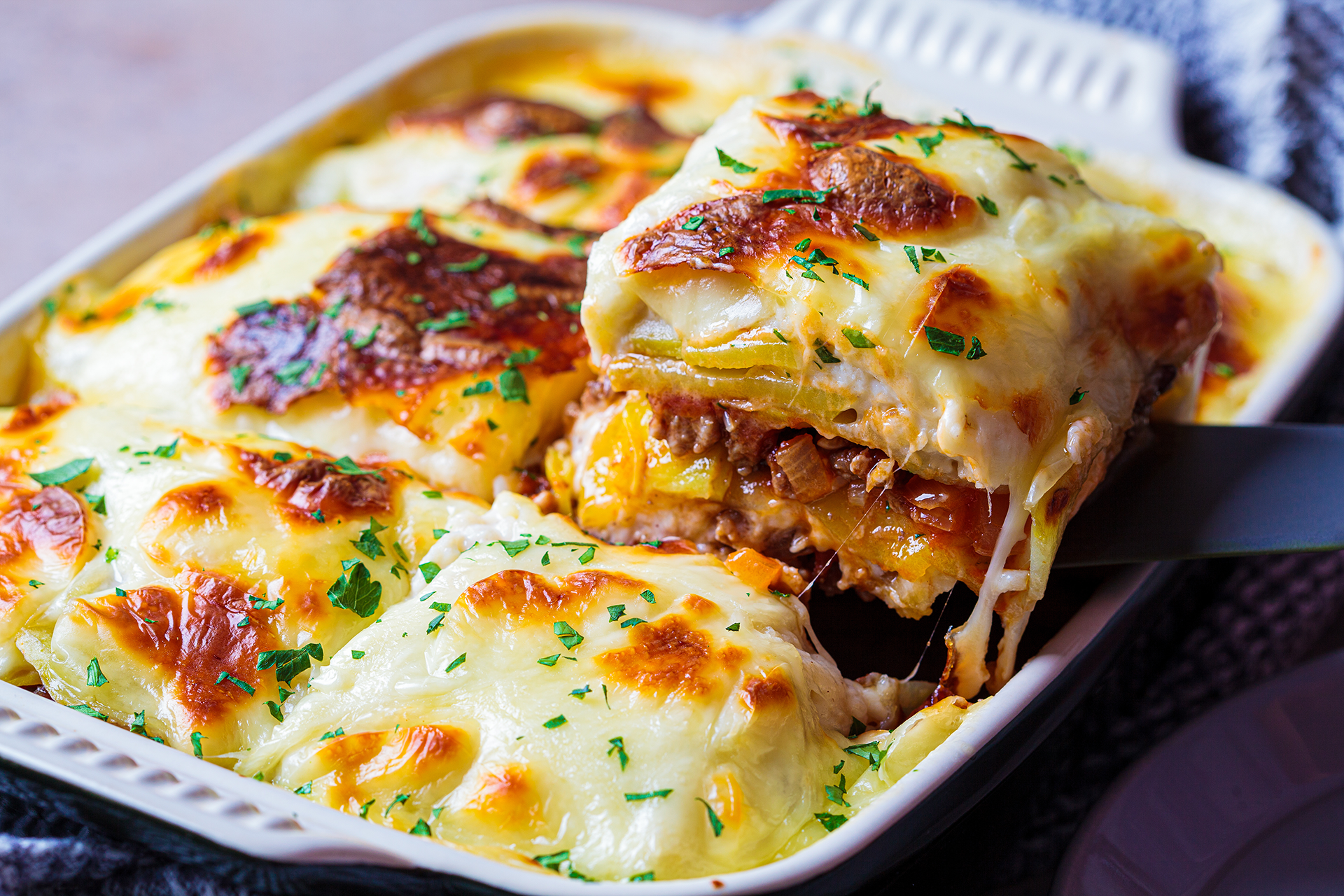 Layers of eggplant, meat, and potatoes baked to golden perfection